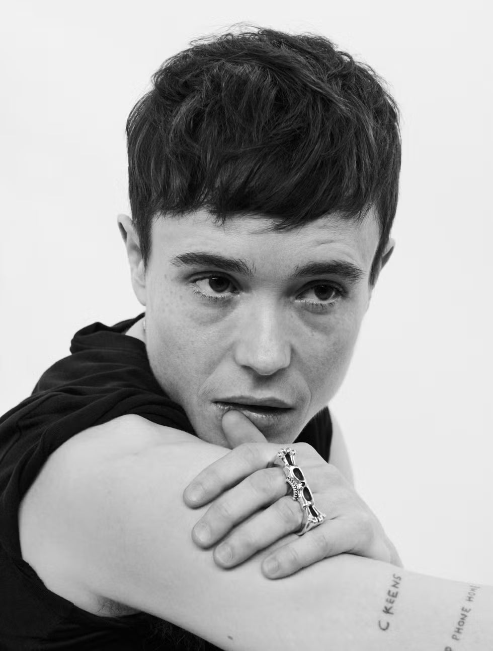 Elliot Page tattoos: Black-and-white portrait with EP PHONE HOME and C KEENS visible on the arm