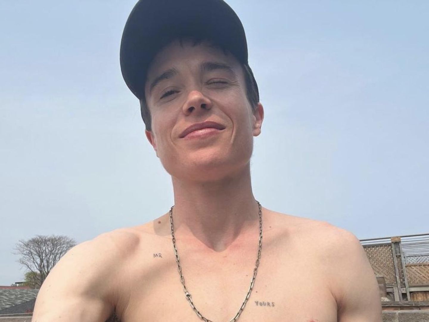Elliot Page tattoos: Casual portrait with MR and YOURS chest tattoos clearly visible