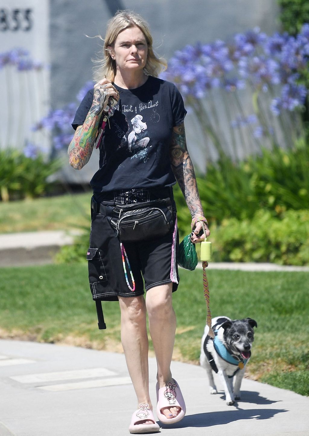 Erika Eleniak tattoos: Candid dog-walking photograph showing both sleeves in a natural pose