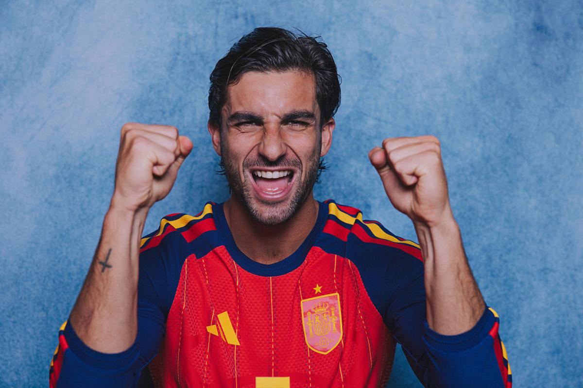 Ferran Torres tattoos: Face-visible official portrait in Spain kit with the cross tattoo clearly visible on his forearm