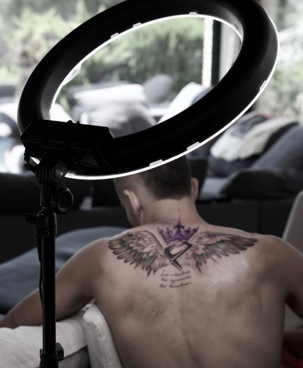 Ferran Torres tattoos: Seated rear view clearly showing the phoenix wings, central crowned FT emblem and lettering across Ferran’s upper back