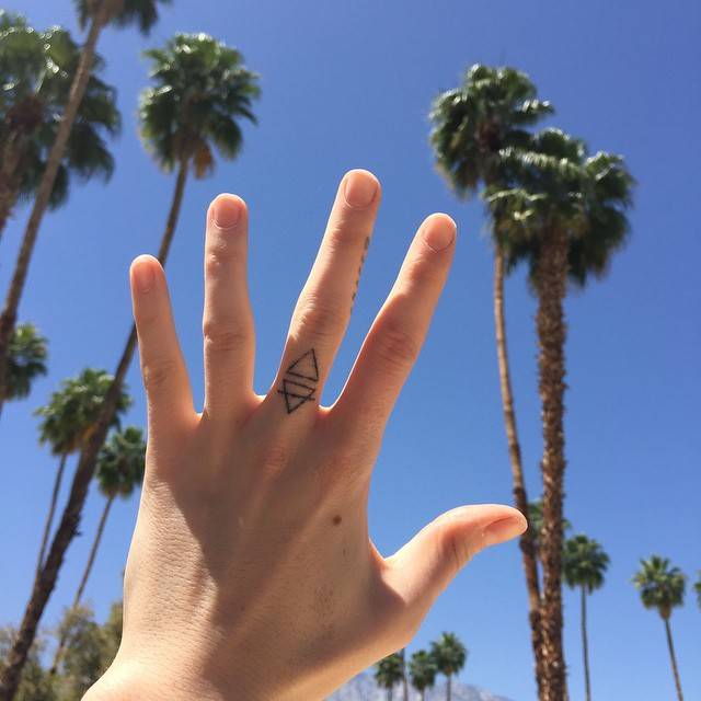 Florence Welch fire and earth alchemy finger tattoos