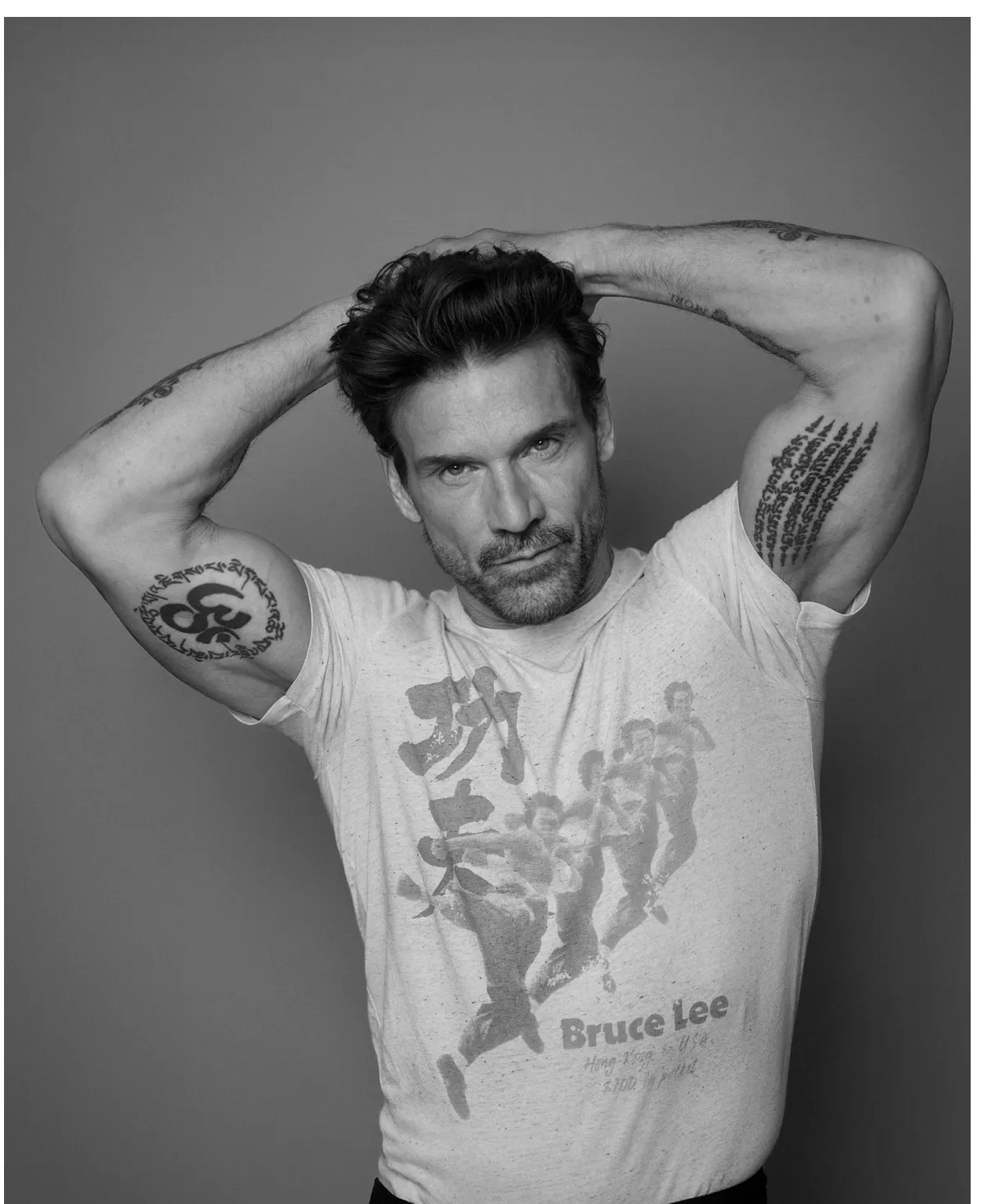 Frank Grillo tattoos: high-resolution portrait showing both upper arms and contrasting tattoo work