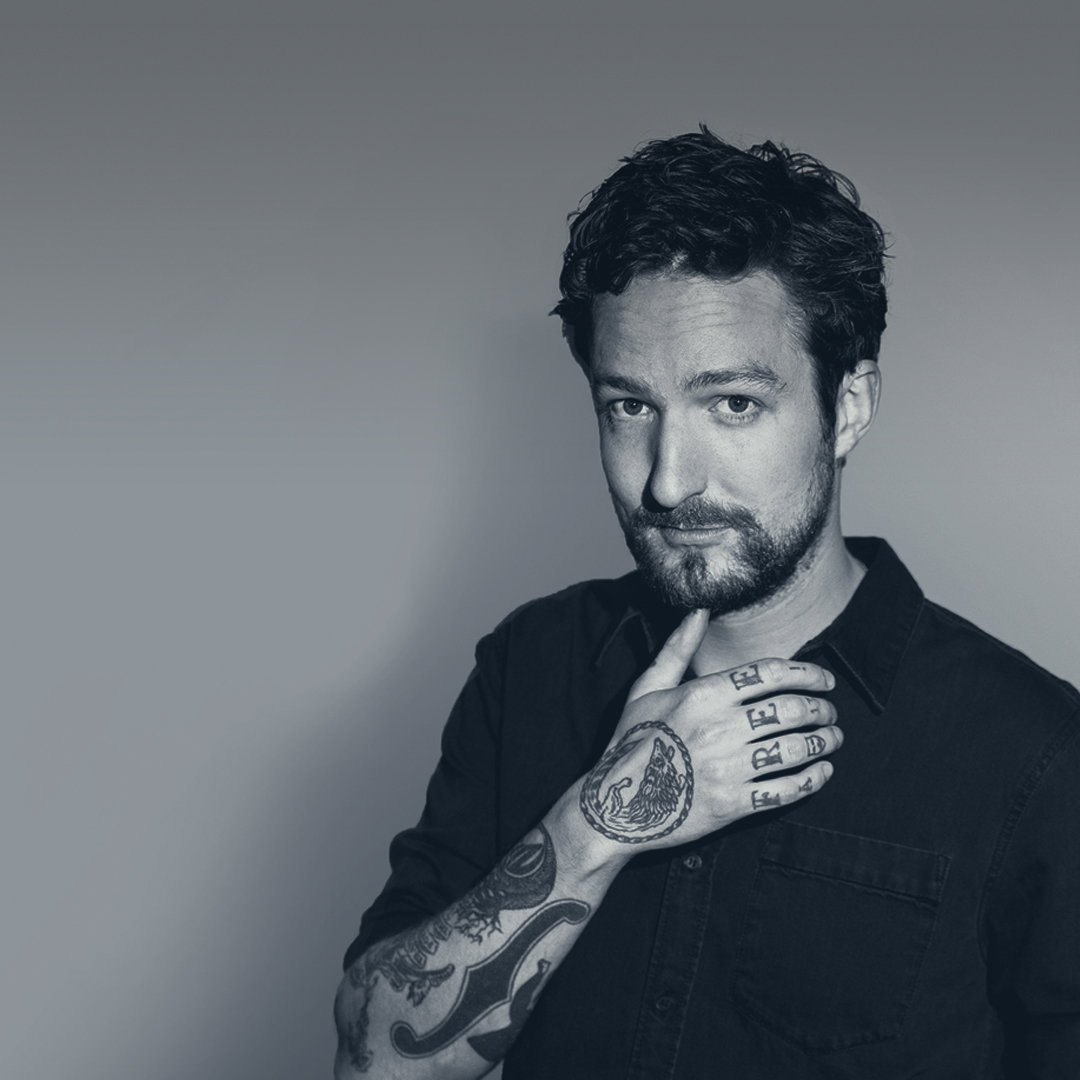 Frank Turner tattoos: Genuine tattoo photograph showing Frank Turner’s face and raised forearm sleeve.