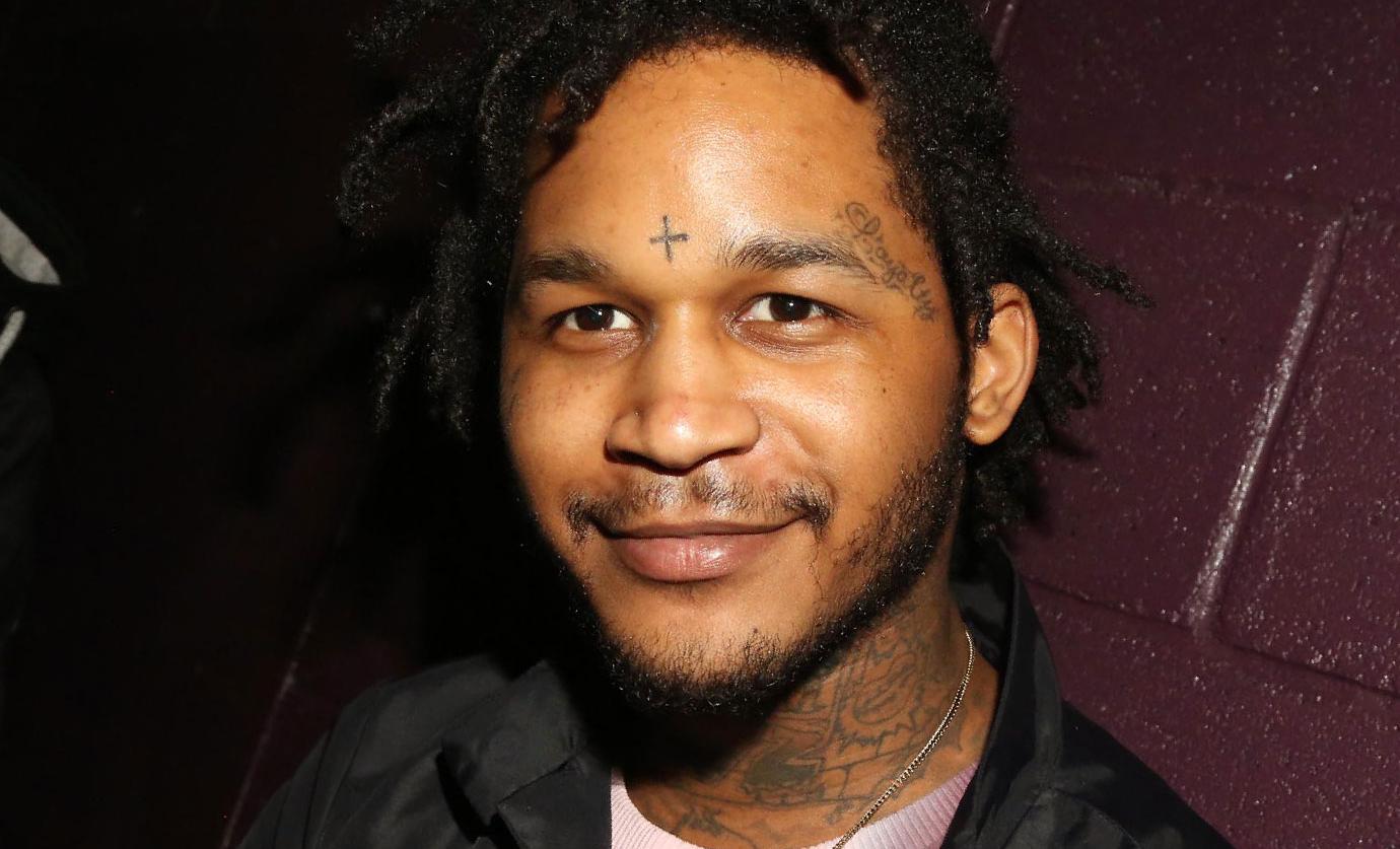 Fredo Santana tattoos: the forehead cross, temple script and neck tattoos in a face-visible portrait
