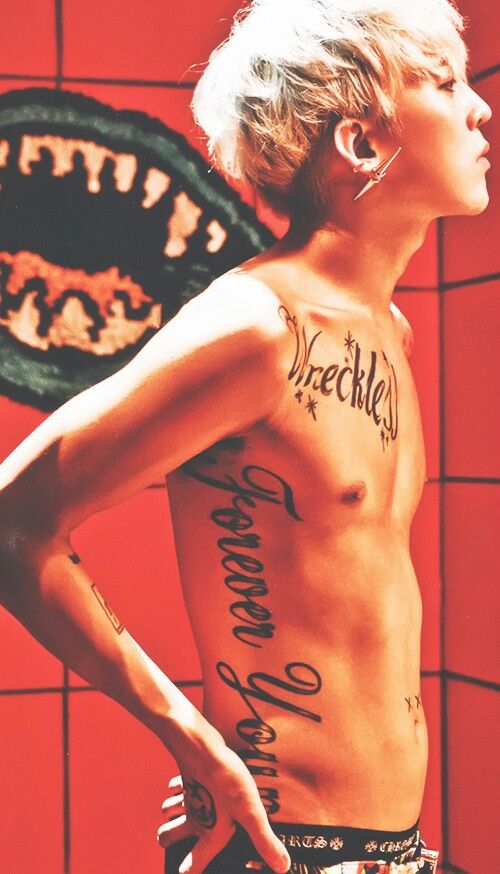 G-Dragon showing his Wreckless and Forever Young tattoos