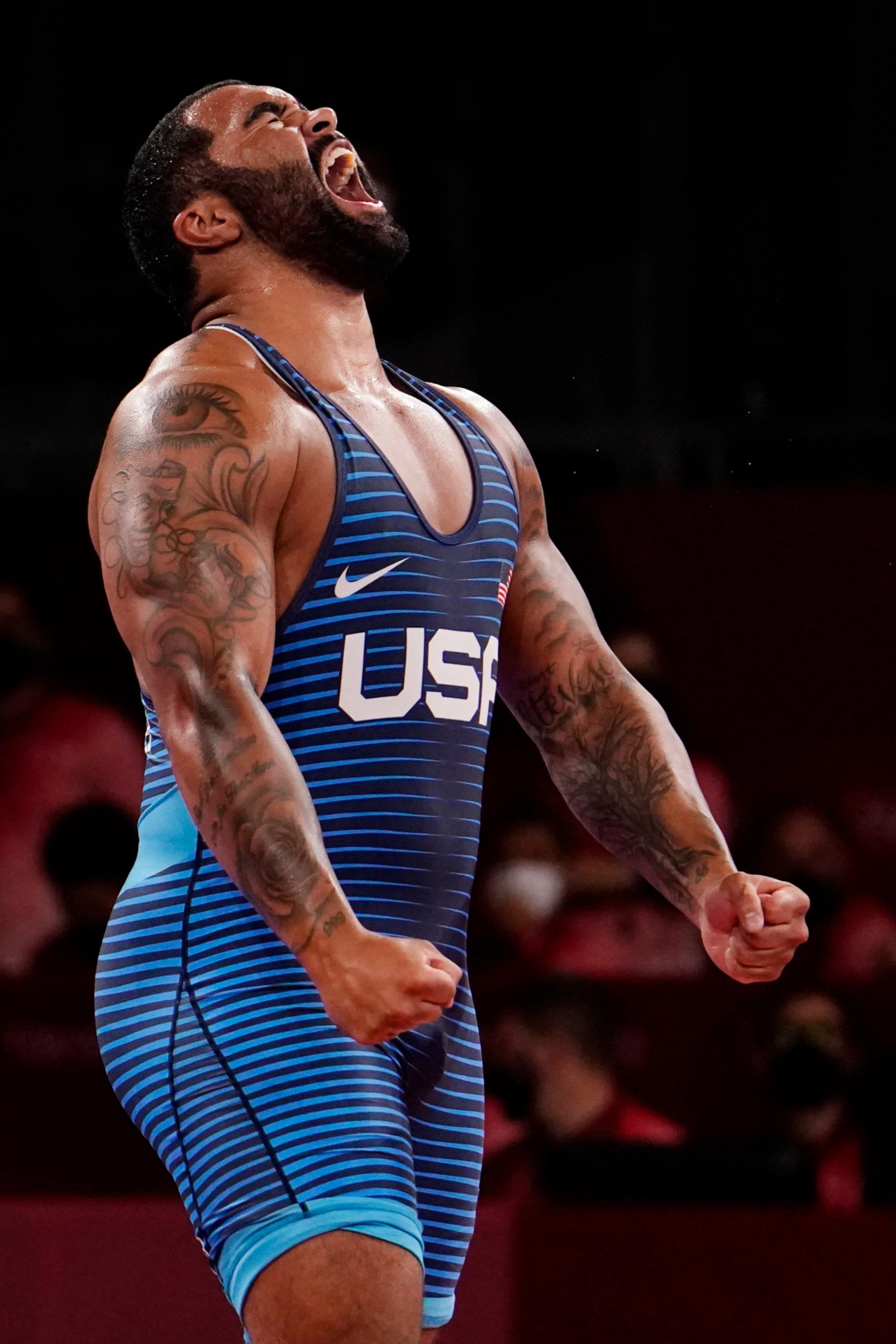 Gable Steveson tattooed arms in official wrestling photograph Gable Steveson tattoos: Official Team Gable wrestling photograph showing both tattooed arms and chest composition.