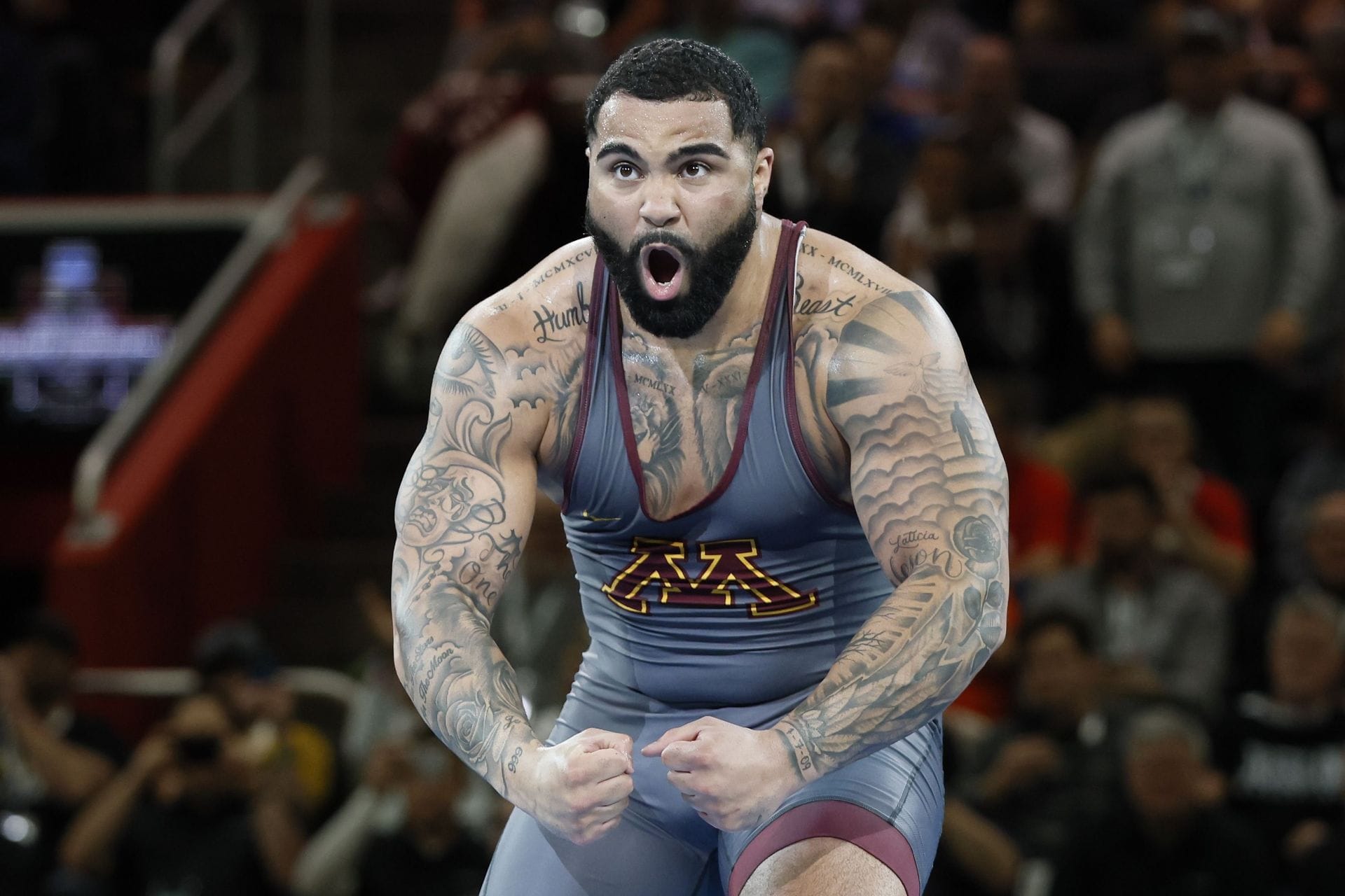 Gable Steveson tattoos during wrestling match Gable Steveson tattoos: Sports photograph showing large upper-arm and chest imagery in competition.