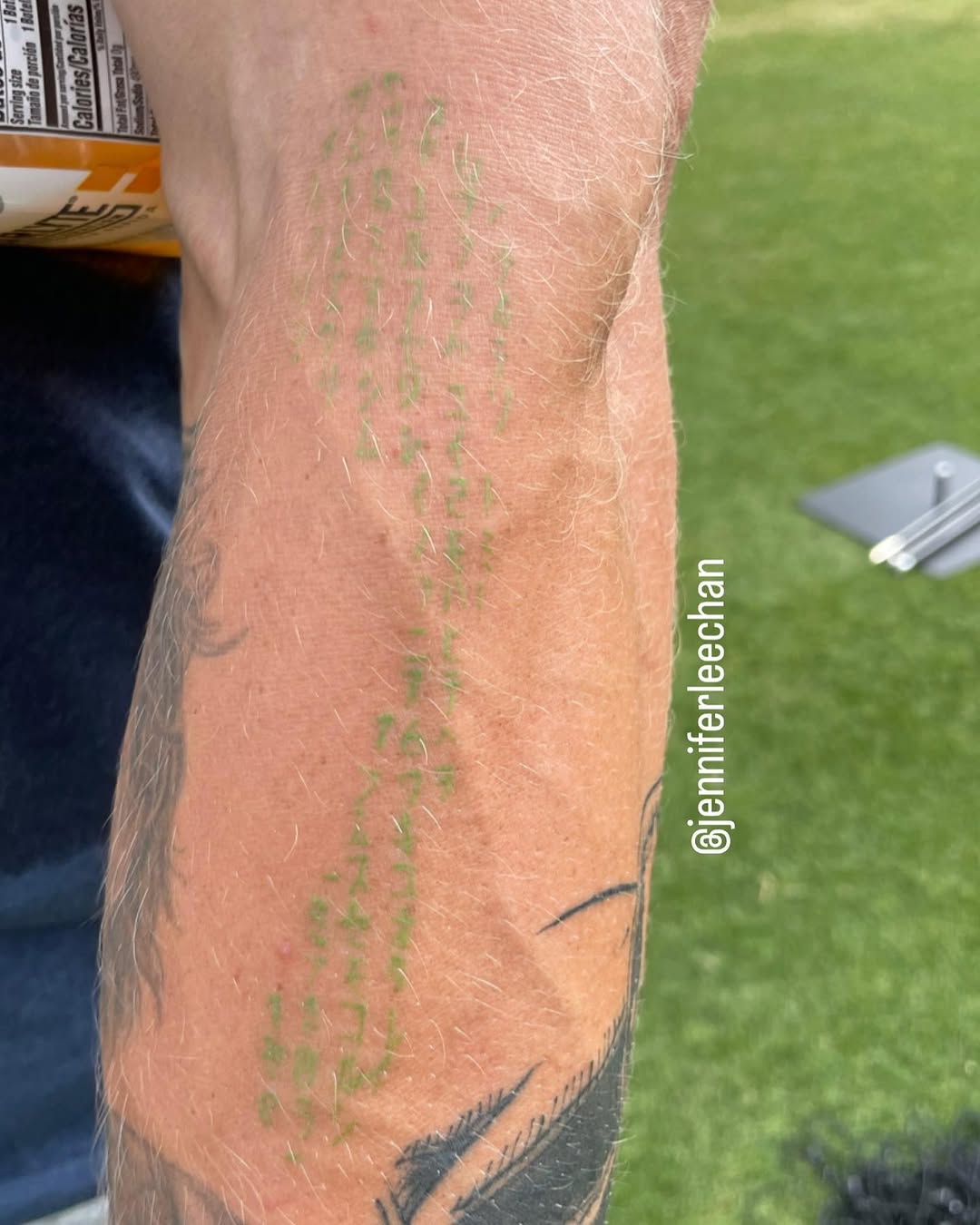 George Kittle tattoos: close forearm photograph showing the green digital-rain marks