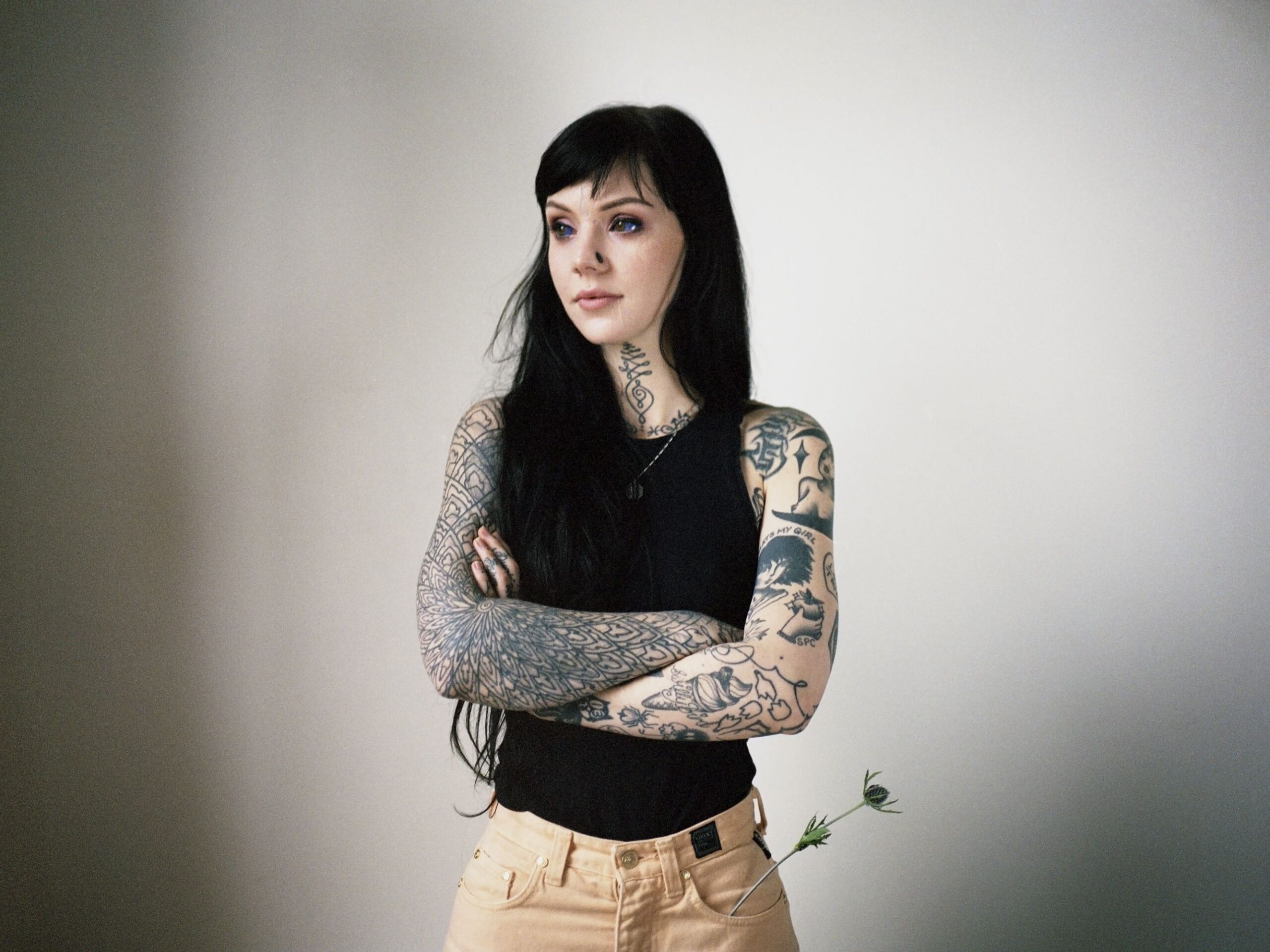 Grace Neutral tattoos: Geometric arm coverage and neck tattoo details