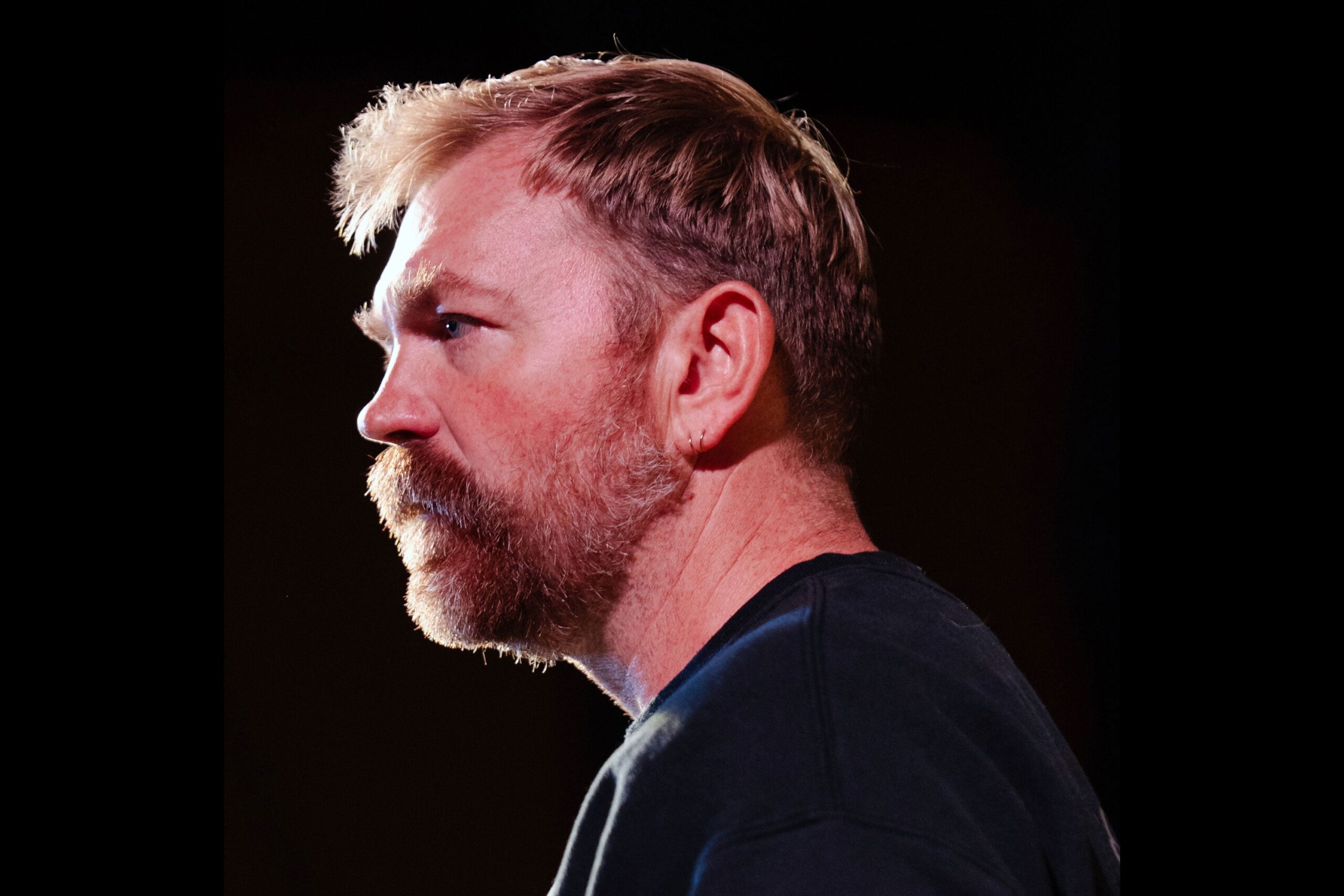 Graham Platner in a contextual photograph: Contextual speaking portrait, not tattoo evidence.; not tattoo evidence