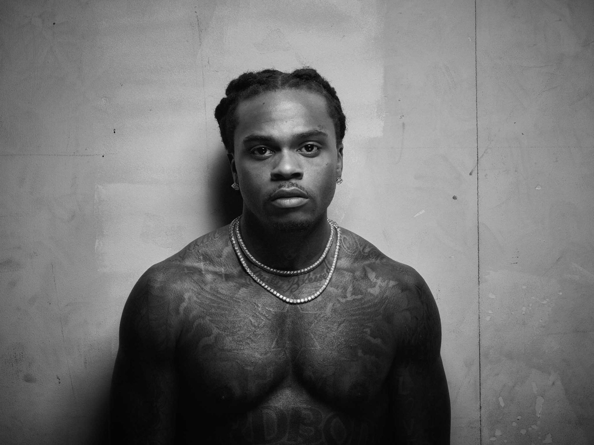 Gunna tattoos: neck, chest, and hand-adjacent tattoo details in a portrait