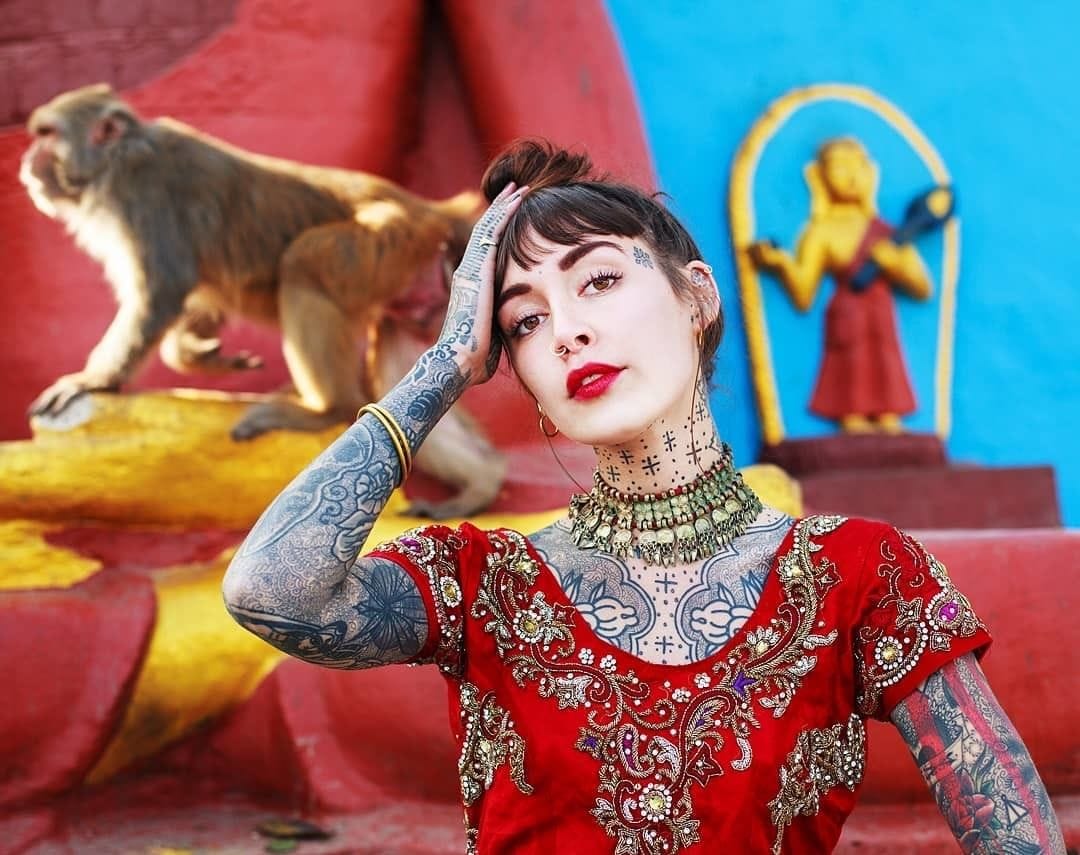 Hannah Snowdon tattoos: red temple portrait showing arm and chest tattoos
