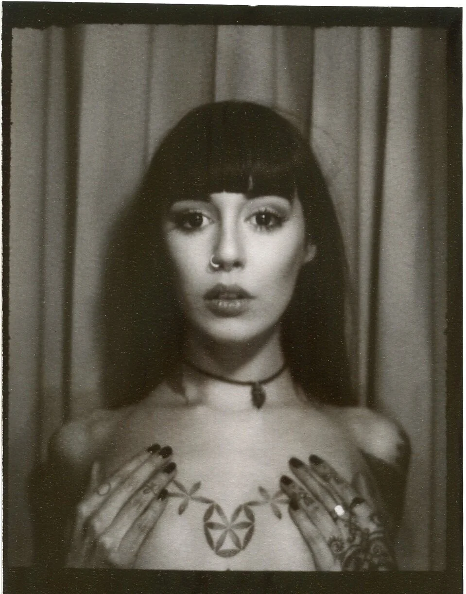 Hannah Snowdon tattoos: self portrait showing chest and hand tattoo details