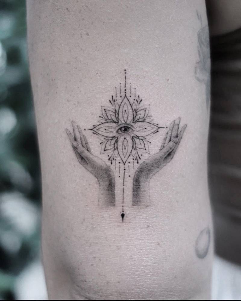 Hilary Duff tattoos: lotus and evil-eye arm tattoo with hands and fine-line rays