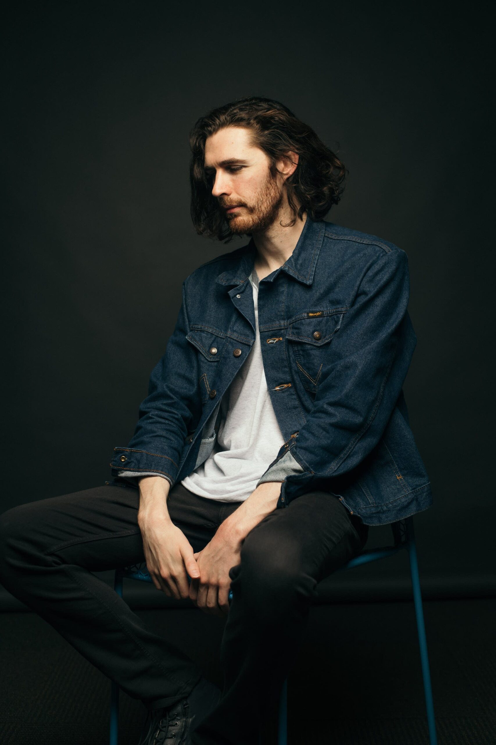 Hozier contextual seated studio portrait Hozier tattoos: Contextual seated studio portrait of Hozier; this photograph does not show tattoo evidence