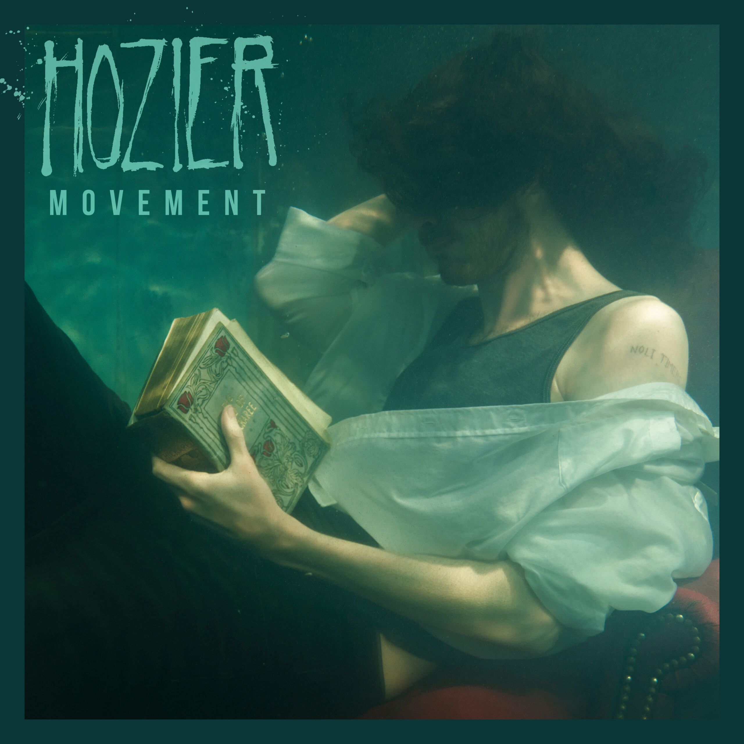 Hozier Noli Timere tattoo in Movement artwork Hozier tattoos: Noli timere lettering clearly visible on Hozier’s shoulder in the Movement artwork