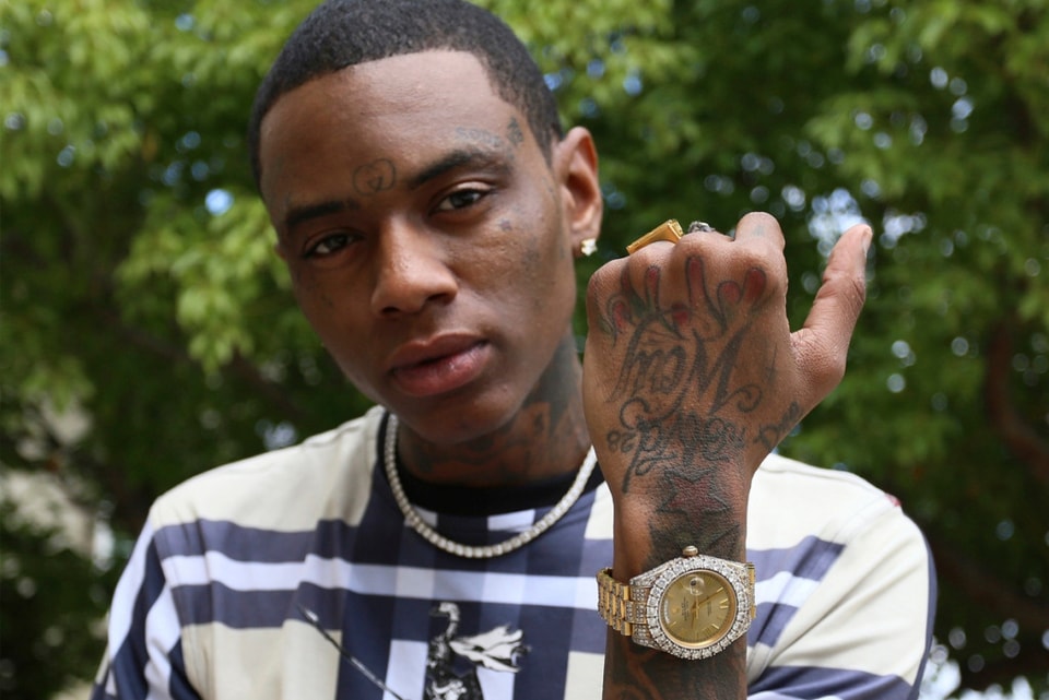 Soulja Boy tattoos: sharp outdoor portrait focused on hand lettering, wrist ink, and face tattoos