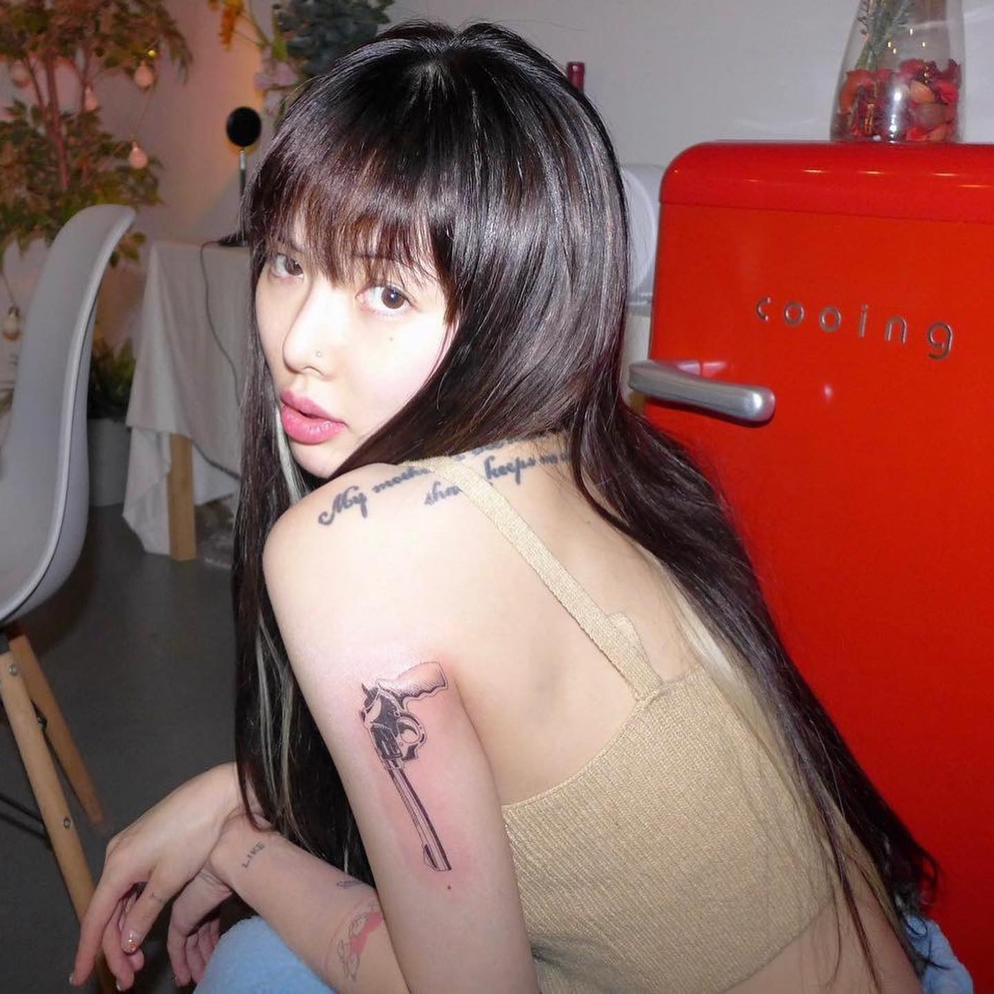 HyunA tattoos: revolver-like upper-back outline