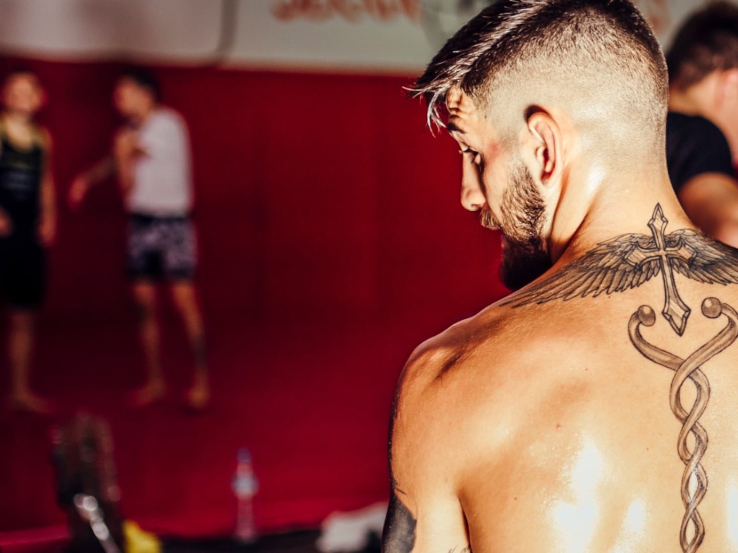 Ilia Topuria tattoos: winged cross and back tattoo