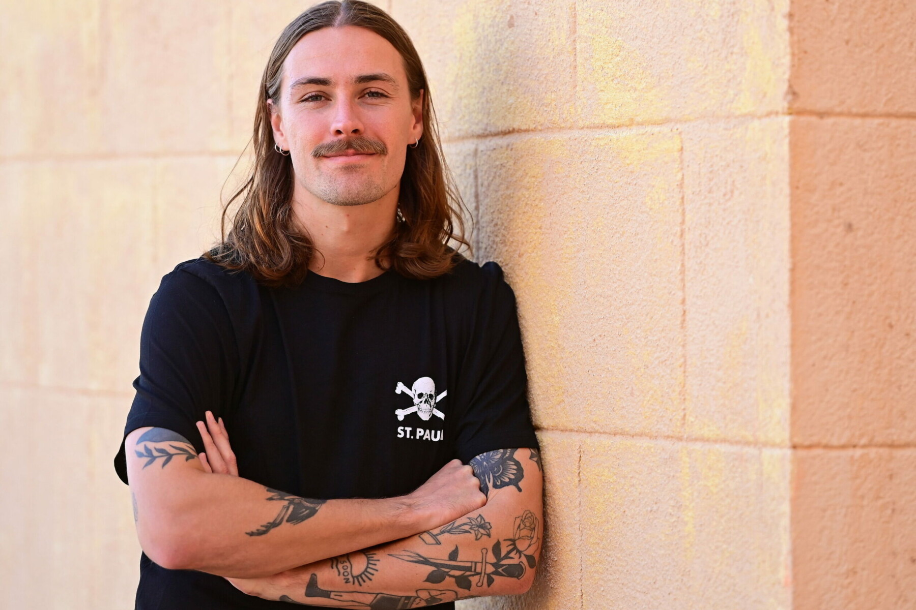 Jackson Irvine Separate arms-crossed interview photograph; clear view of tattooed arms supports the description of a varied patchwork rather than one continuous sleeve. Jackson Irvine tattoos: Separate arms-crossed interview photograph; clear view of tattooed arms supports the description of a varied patchwork rather than one continuous sleeve.