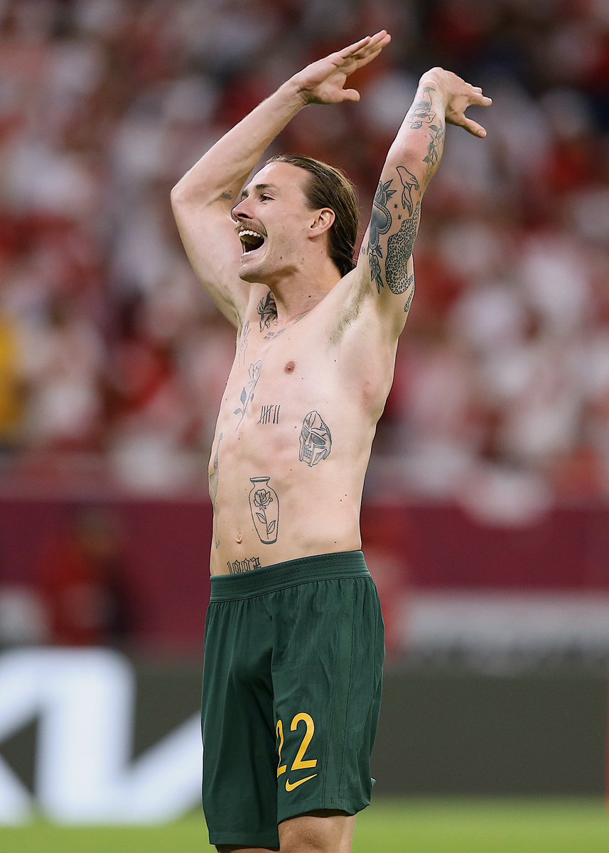 Jackson Irvine Separate shirtless celebration photograph showing real torso and arm tattoos; placed in the wider-collection section and not used to imply that it depicts any particular named design. Jackson Irvine tattoos: Separate shirtless celebration photograph showing real torso and arm tattoos; placed in the wider-collection section and not used to imply that it depicts any particular named design.