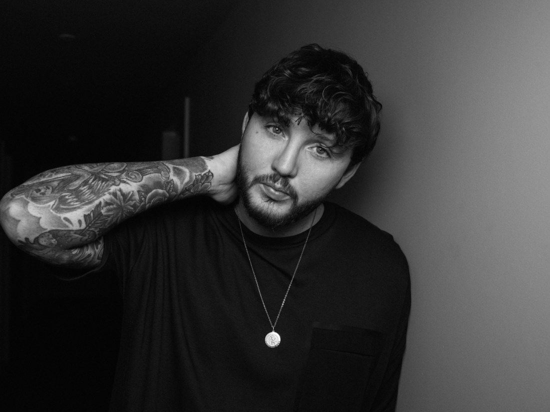 James Arthur tattoos: black-and-grey sleeve with flowers, curved forms and overlapping shaded pieces