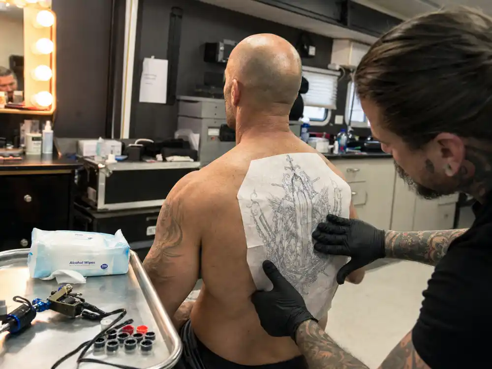 Jason Statham tattoos: behind-the-scenes tattoo transfer being applied to the actor's back