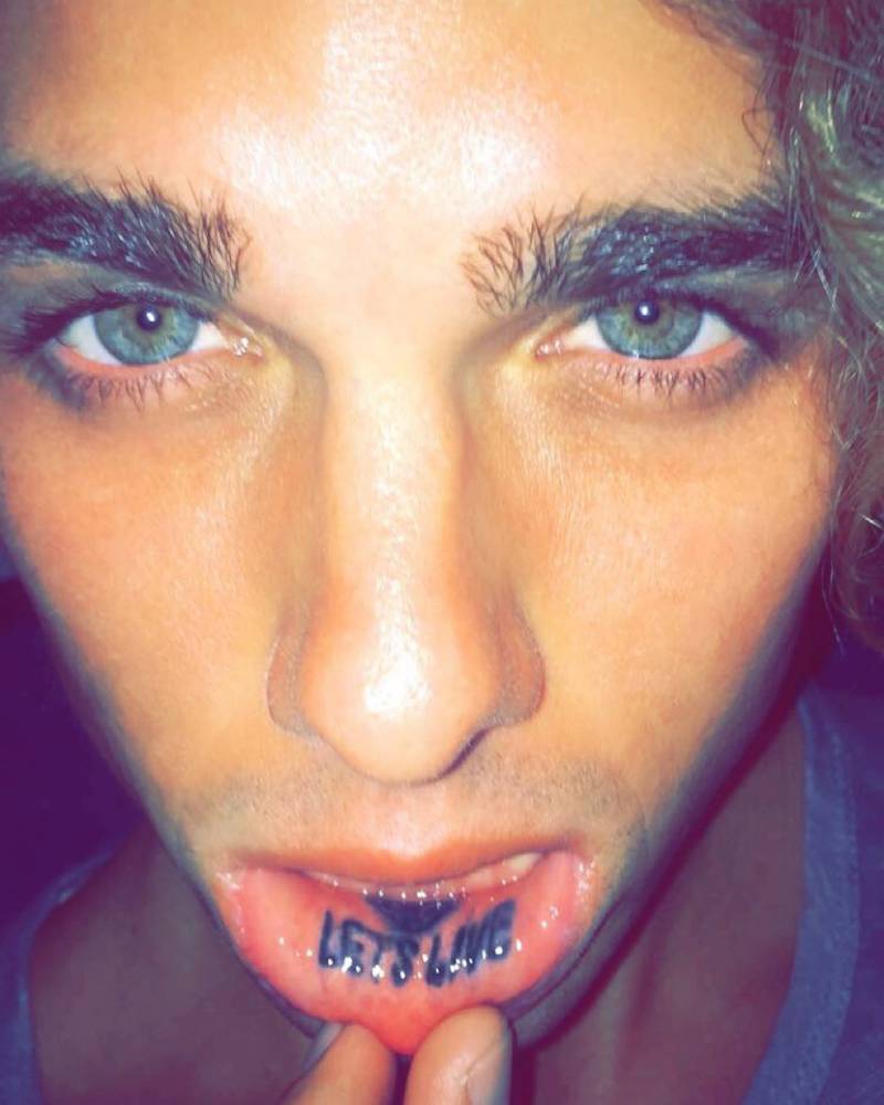 Jay Alvarrez lower lip Let's Live tattoo