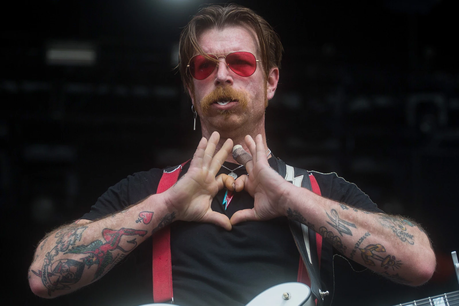 Jesse Hughes tattooed arms during a heart gesture
