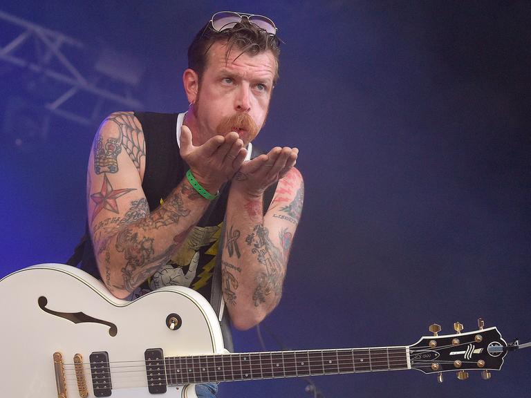 Jesse Hughes arm tattoos during a live performance