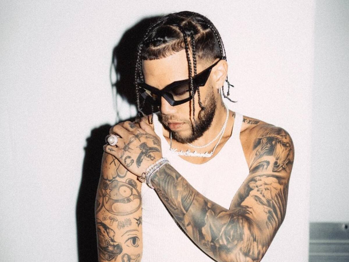 Jhayco tattoos: Published portrait clearly showing extensive tattoos across both arms and shoulders.