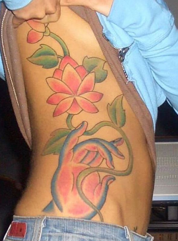 Jhene Aiko hand holding lotus rib tattoo