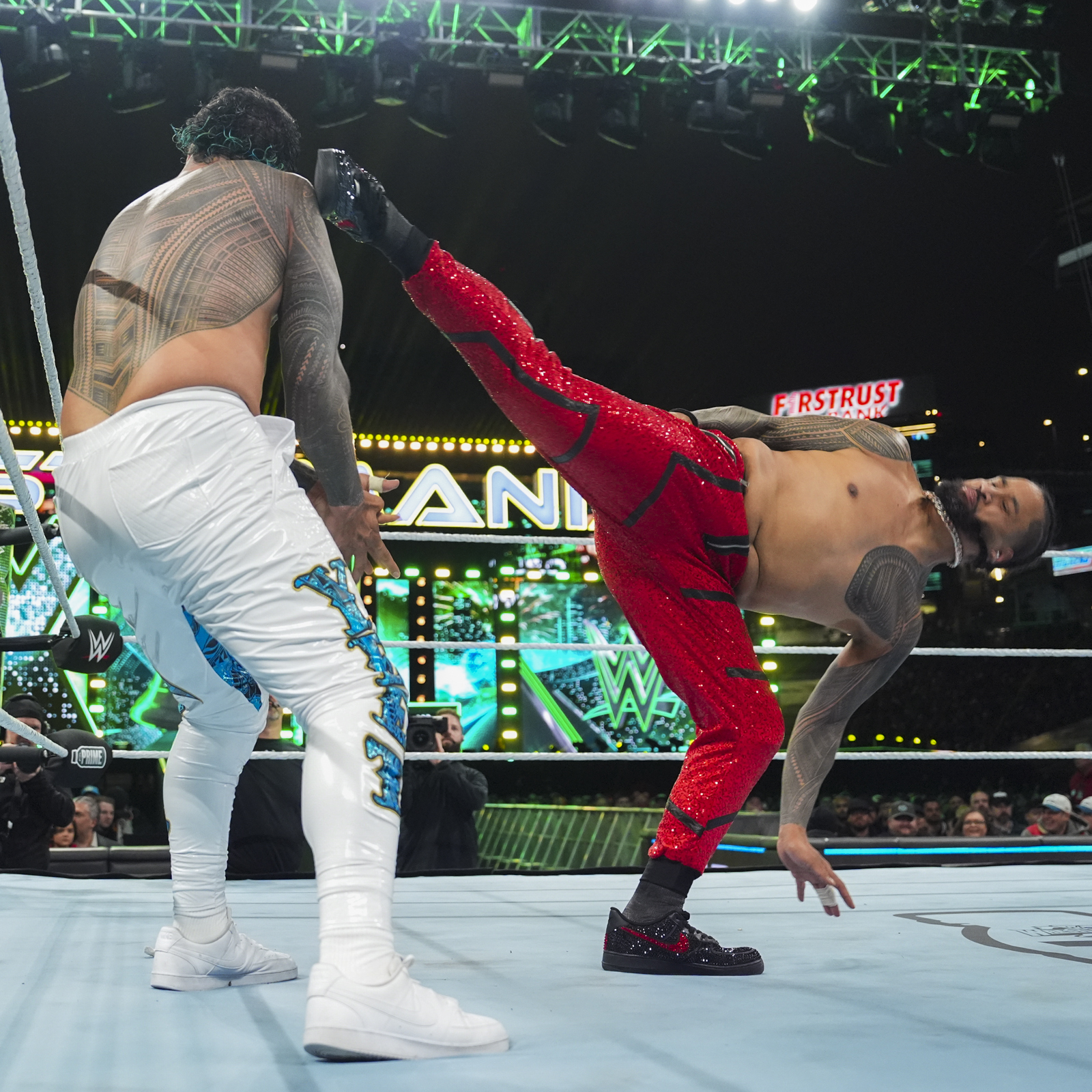 Jimmy Uso tattoos: Left sleeve exposed on Jimmy in red pants during a superkick