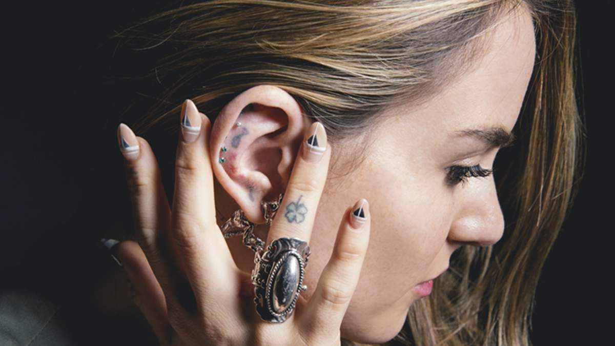 JoJo ear and finger tattoos