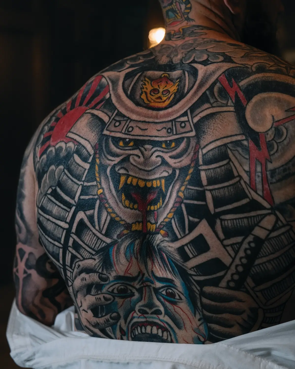 Jordan Shallow tattoos: Inked close photograph showing the large illustrative chest piece with its armored figure and color accents