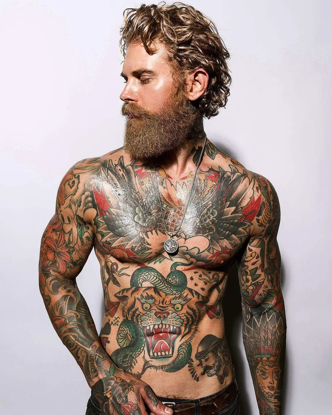 Josh Mario John tattoos: Spread-wing eagle across the chest with a flower above it and bold red-and-black framing.