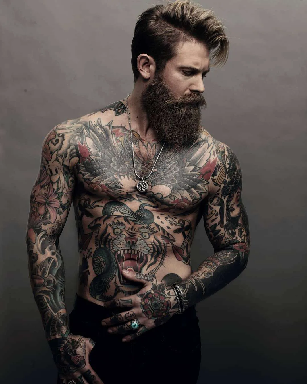 Josh Mario John tattoos: Open-mouthed tiger on the abdomen with a green snake looping around its head.