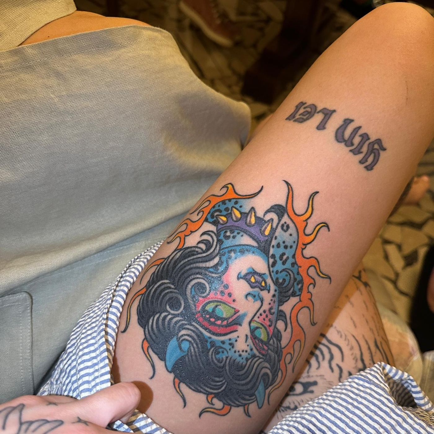 Josie Man tattoos: Close view of the bright traditional cat-devil woman’s face tattoo with flames, inspected at full resolution.