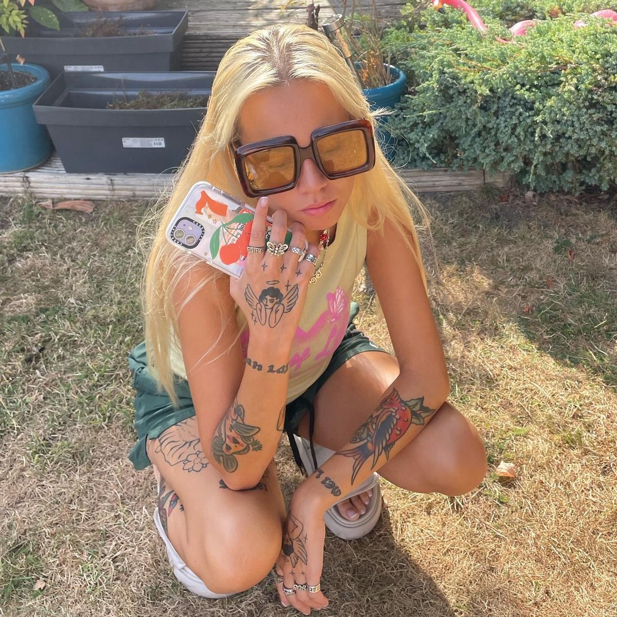 Josie Man tattoos: A distinct outdoor photograph showing the colorful tiger on her leg along with hand and arm tattoos.