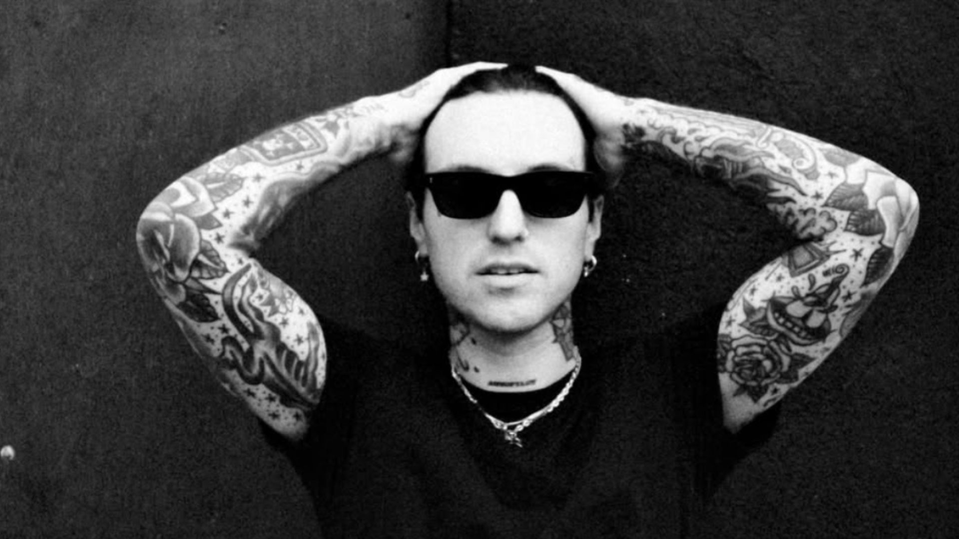 Jutes showing the tattooed forearms connected to his first quote tattoo Jutes tattoos: wide editorial portrait showing Jutes' tattooed forearms, hands and neck around the documented quote area