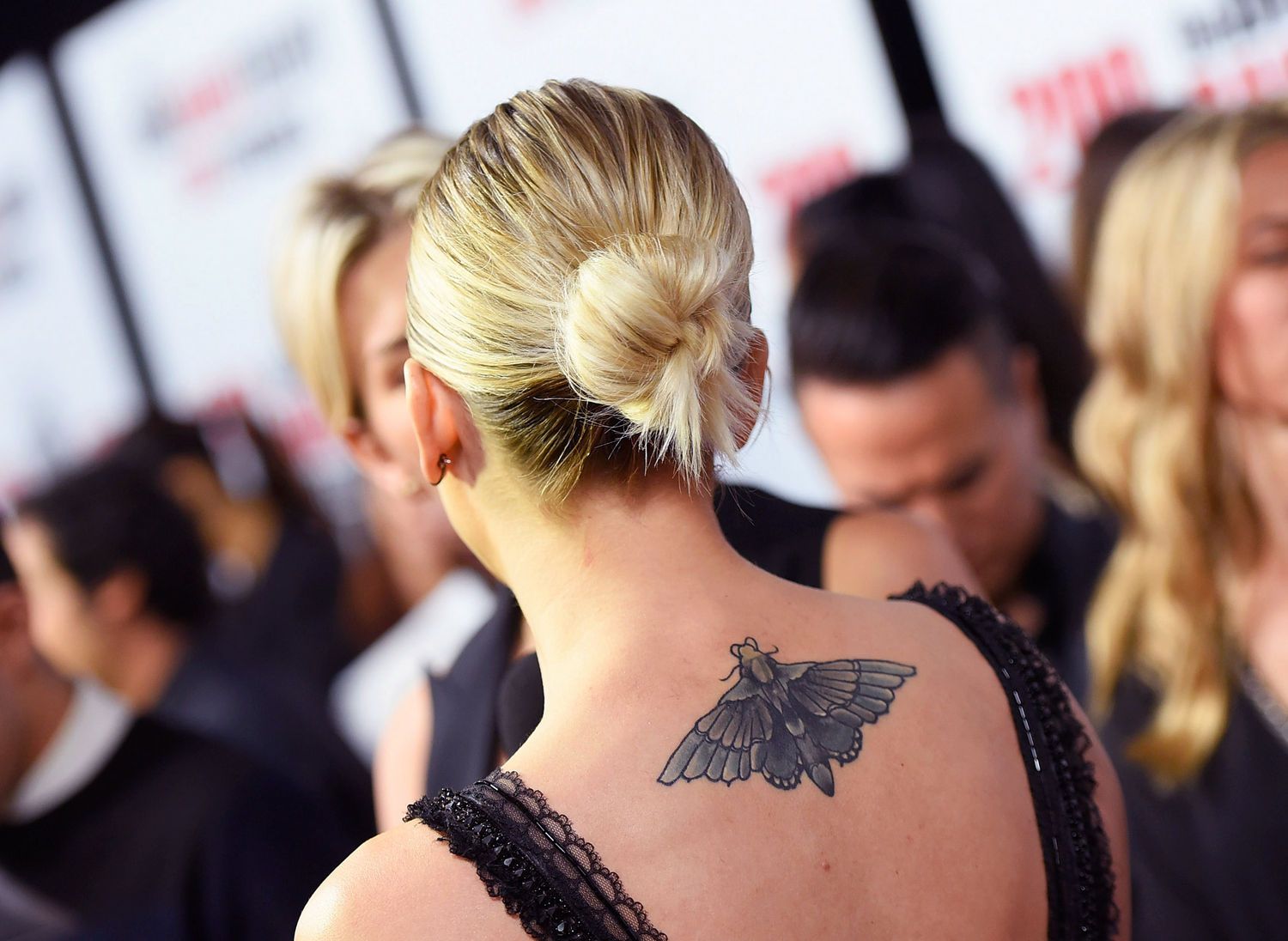 Kaley Cuoco tattoos: Close editorial photograph showing the broad shaded moth cover-up across Cuoco's upper back.