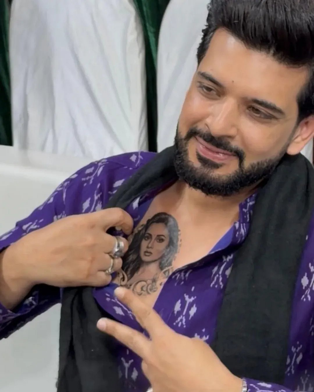 Karan Kundrra tattoos: Genuine tattoo photograph showing Karan opening his shirt and pointing to the chest portrait.