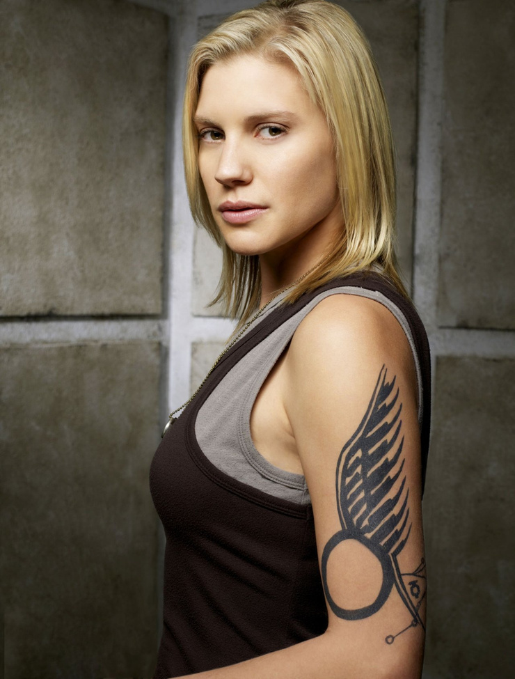 Katee Sackhoff tattoos: close portrait showing the feather-like linework and circular lower form of Sackhoff’s winged tattoo
