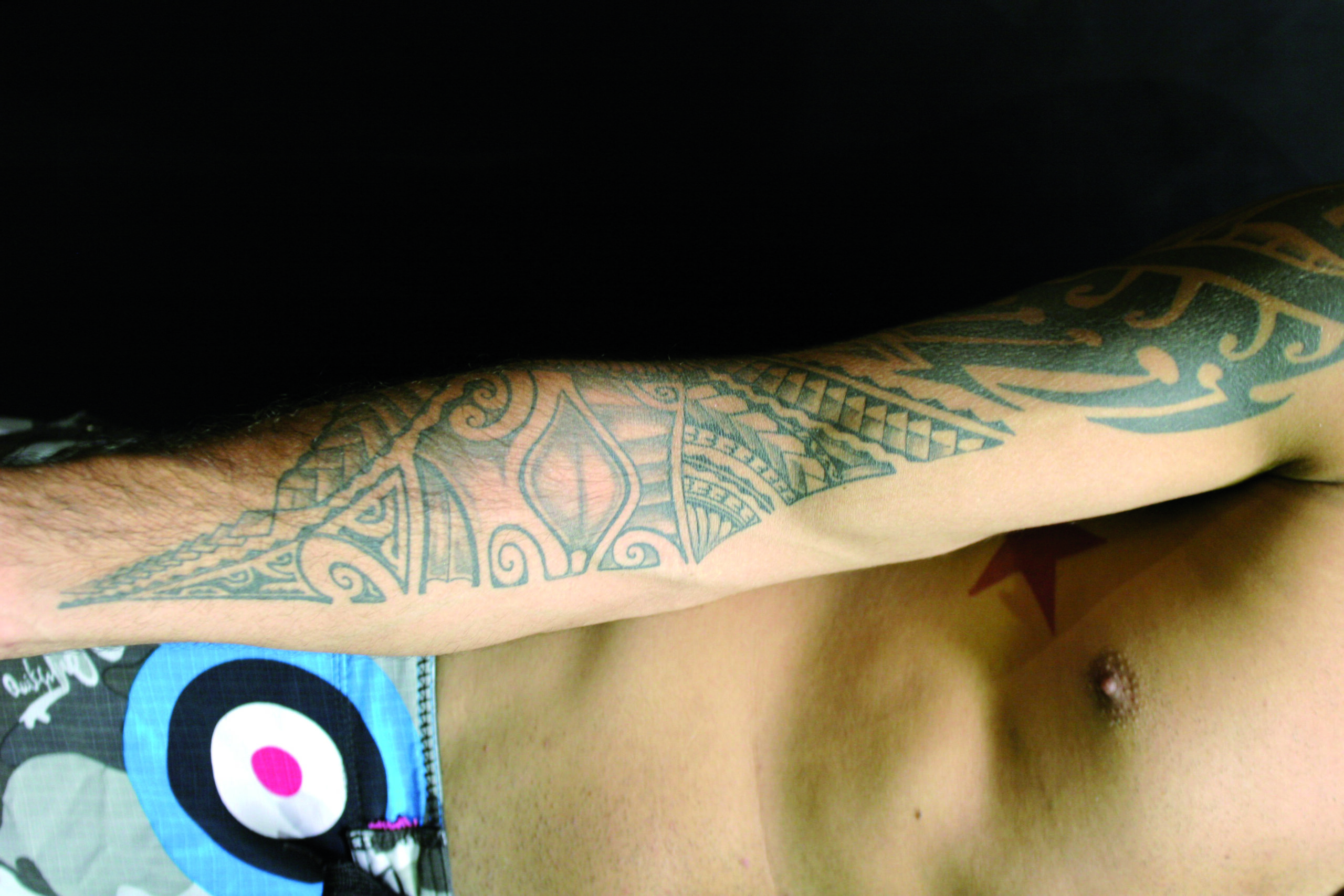 Kendall Grove: Tiki face and bold right-arm patterns Kendall Grove tattoos: Tiki face and bold right-arm patterns