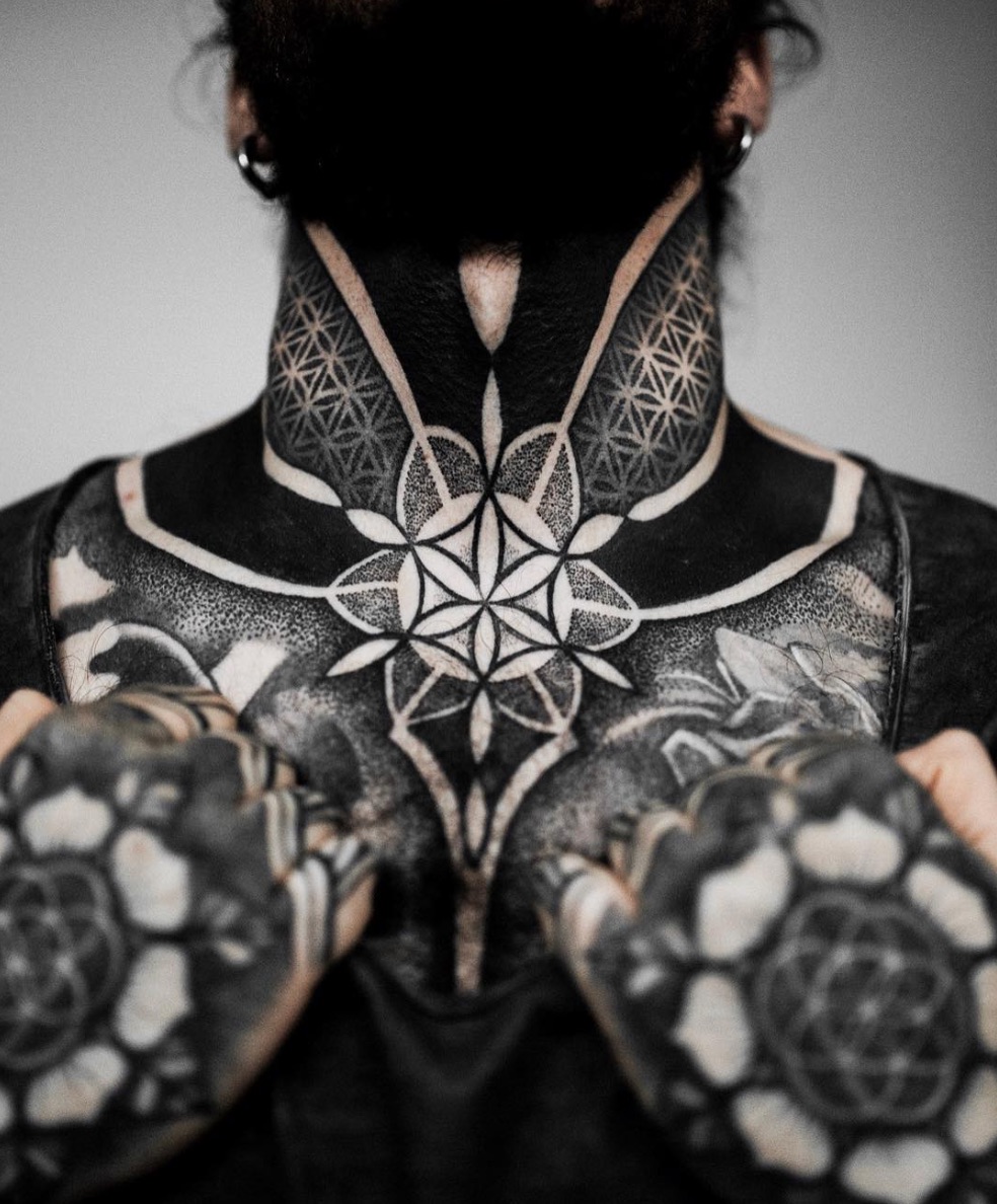 Kevin Creekman tattoos: Centered seed-of-life throat motif and patterned blackwork collar