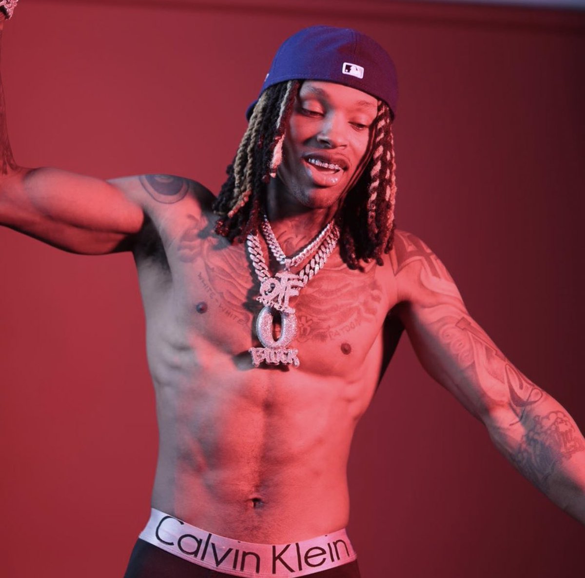 King Von tattoos: high-resolution shirtless portrait showing the chest, neck, shoulders and both tattooed arms