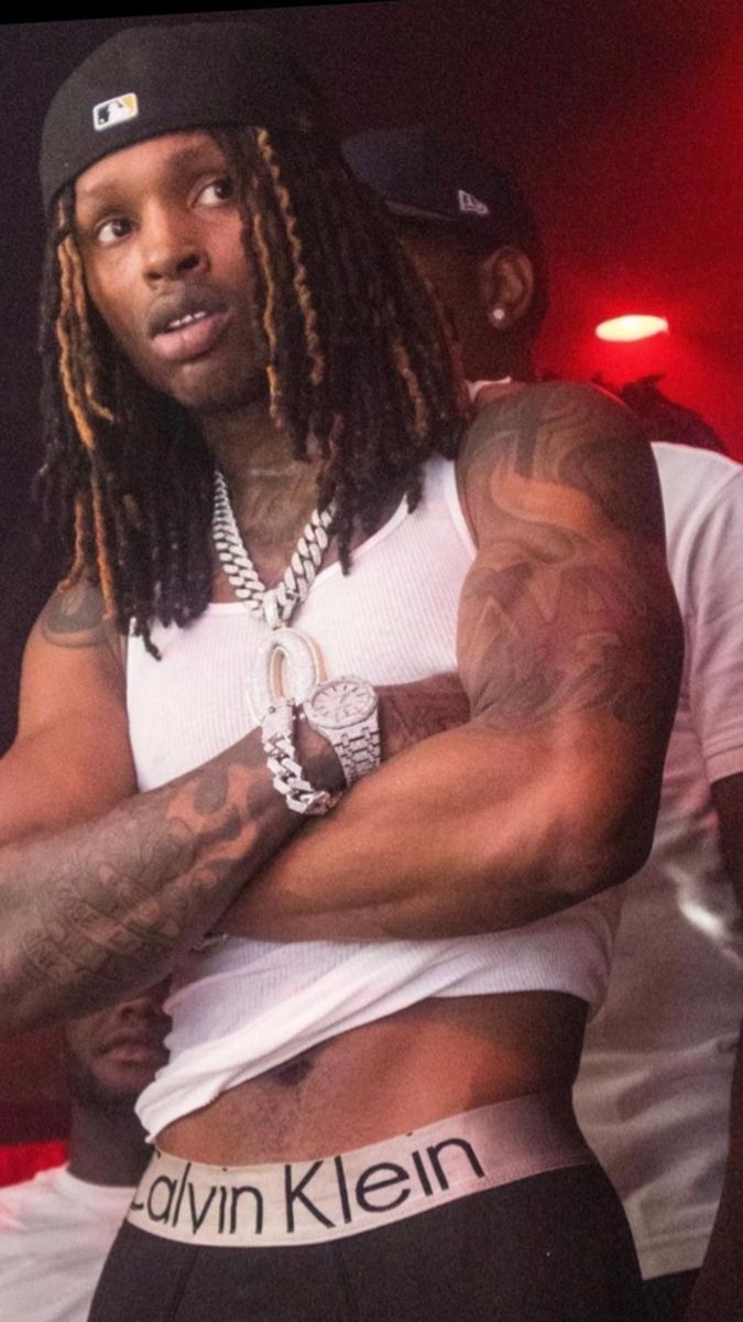 King Von tattoos: high-resolution stage portrait showing a separate angle of the arm, chest and shoulder tattoos