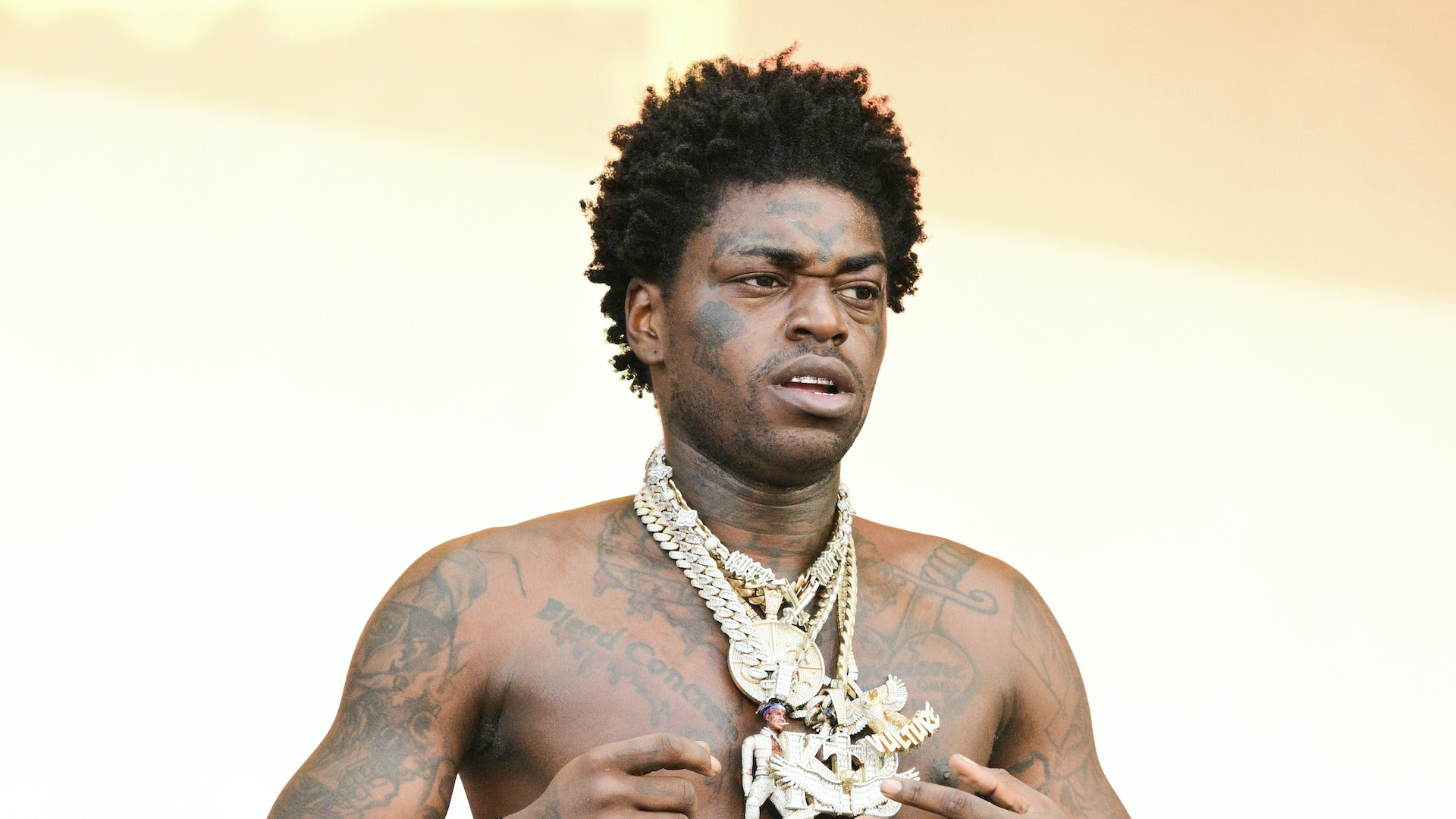 Kodak Black performing with his chest and arm tattoos visible