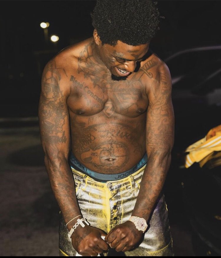 Kodak Black shirtless with his chest, arms and stomach tattoos visible